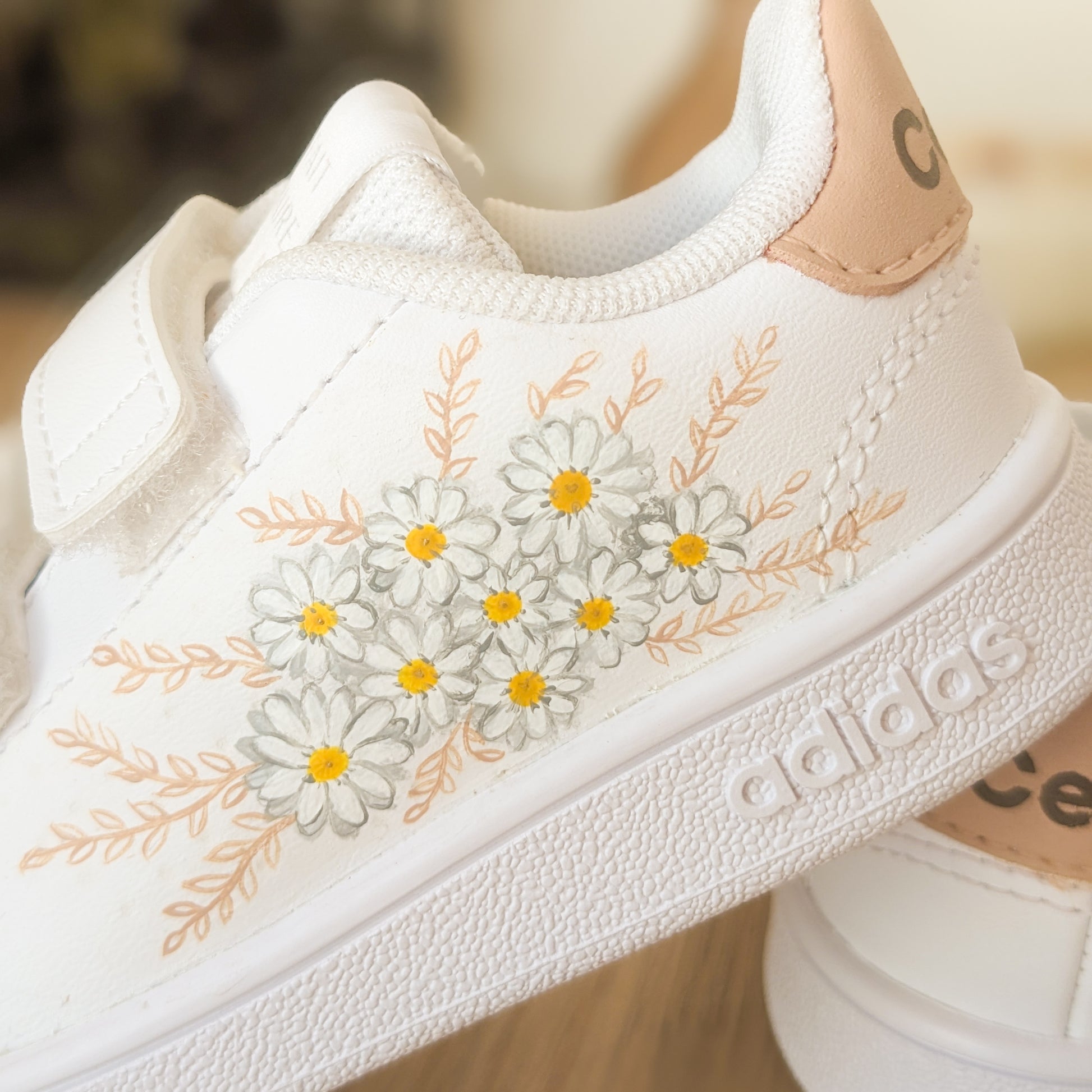 Vue en détail des baskets pour enfant customisées à la main de petites fleurs blanches